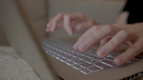 Hands typing on laptop keyboard while sitting on sofa Stock Footage 327159139
