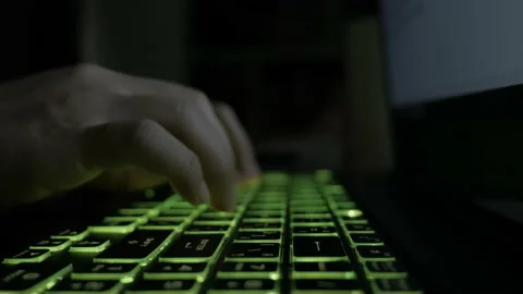 Hands typing on laptop LED keyboard with colorful lights effect in the darkroom. Video stock 165680817