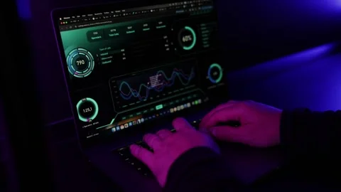 Hands typing on Laptop with statistics and Analytics in Dark Neon Office Stock Footage 336582957