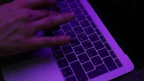 Hands typing on laptop under blue pink neon light Stock Footage 229705980