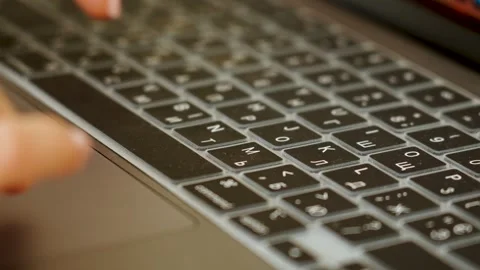 Hands typing on a modern laptop keyboard with Cyrillic characters indoors Stock Footage 335199474