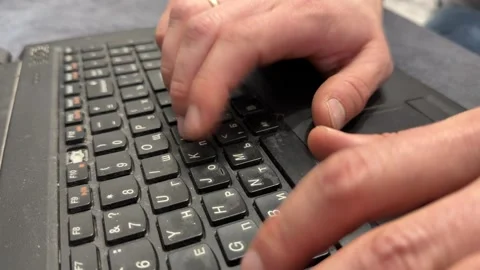 Hands typing on old laptop keyboard close up, outdated computer use for remote Video stock 337121457