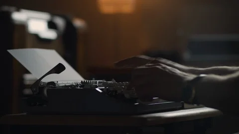 Hands typing at an old vintage typewriter in a moody lit office Stock Footage 97872900