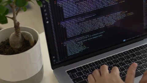 Hands typing programming code on laptop during focused development session Видео 345653725
