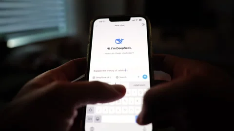 Hands typing question into DeepSeek AI chatbot on phone Stock Footage 302192456