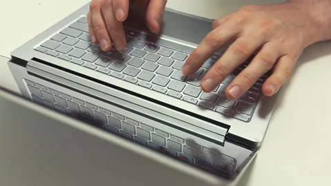 Hands typing quickly on a light gray laptop keyboard in the morning for work or Video stock 317101554