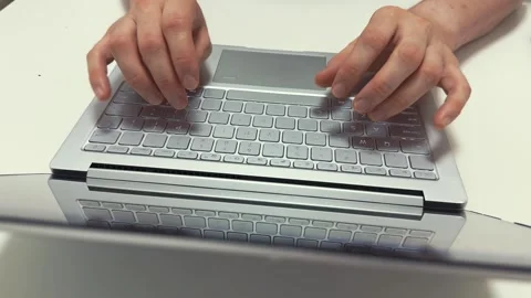 Hands typing quickly on a light gray laptop keyboard in the morning for work or Video stock 317101907