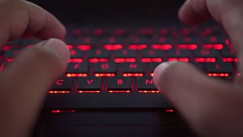 Hands typing on red backlit keyboard, digital lifestyle, programming, and Stock Footage 335977453