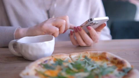 Hands typing on a smartphone in a dimly lit cozy indoor setting with a notebook Stock Footage 277968377