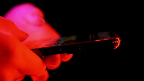 Hands Typing On Smartphone Screen Under Colorful Neon Lights At Night Stock Footage 330176139