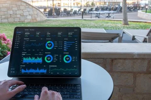 Hands Typing on Tablet with Financial Dashboard at Resort Outdoor Terrace Stock Photos