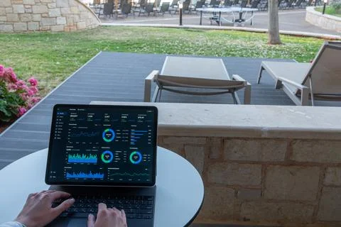 Hands Typing on Tablet with Financial Dashboard at Resort Outdoor Terrace Stock Photos