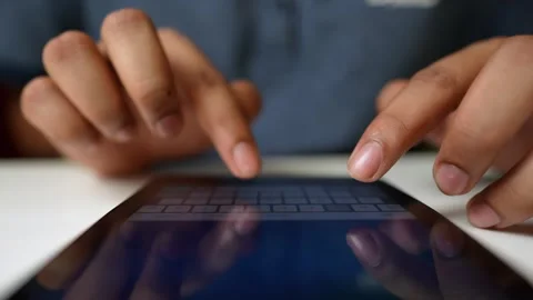 Hands Typing on Tablet Keyboard, Close-up of hands typing on a tablet keyboar Stock Footage 317737040