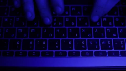 Hands typing text on laptop with blue light high angle Stock Footage 229706300