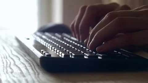 Hands typing text on wireless keyboard on wooden table Stock Footage 131431230