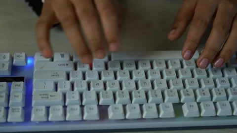Hands typing on white backlit mechanical keyboard, Close-up of hands typing.. Vídeo Stock 329177217