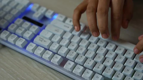 Hands typing on white backlit mechanical keyboard, Close-up of hands typing.. Vídeo Stock 329177273