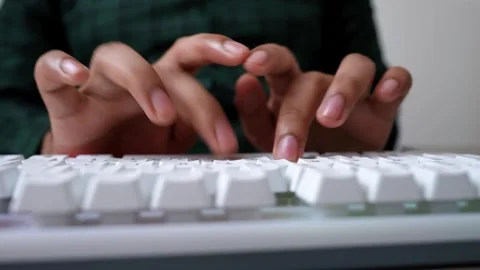 Hands Typing on White Keyboard, Close-up of hands typing on a white keyboard Stock Footage 316902116