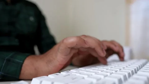 Hands Typing on White Keyboard, Close-up of hands typing on a white keyboar.. Stock Footage 318056588