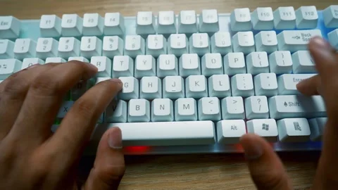 Hands typing on a white mechanical keyboard with RGB lighting Stock Footage 315981437