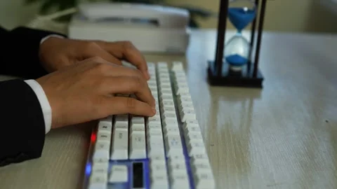 Hands typing on white mechanical keyboard with hourglass Vídeos de archivo 329177337