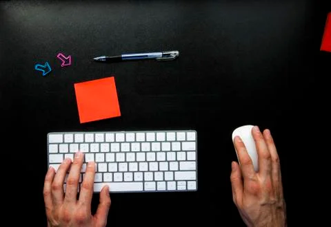 Hands typing on wireless keyboard on black leather desk with copy space Stock Photos