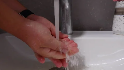 Hands under running water, showcasing the process of washing, with soap bubbles Stock Footage 319529604