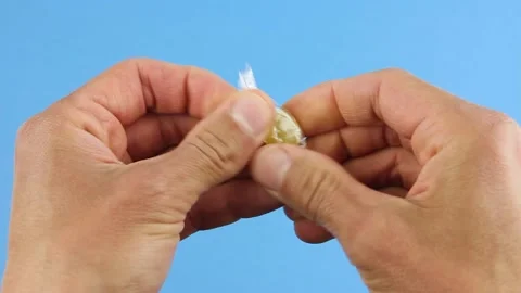 Hands unfold one yellow candy lollipop from a transparent wrapper Stock-Footage 156474670