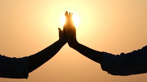 Hands united in front of the sun Stock Footage 252980106