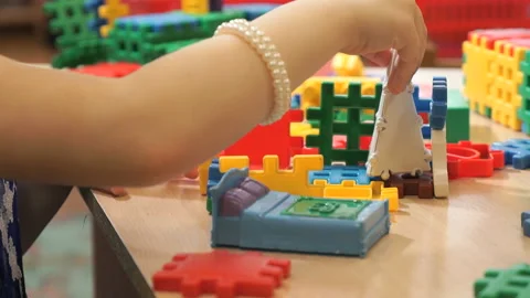 Hands of unknown child playing with building kit Видео 90917498