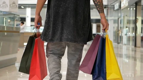 Hands of an unknown hipster man holding bags with buyers during shopping at the 스톡 동영상 98936757