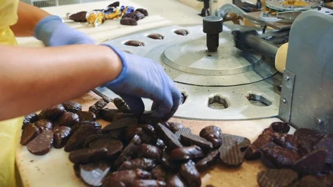 Hands of unrecognizable female worker putting chocolate candies into wrapping Stock Footage 98011490