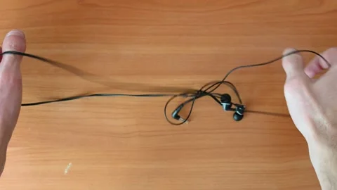 Hands untangle the headphones Stock Footage 178012274