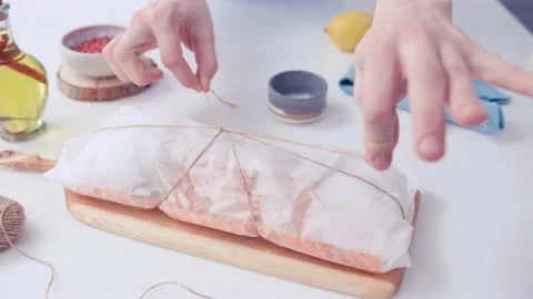 Hands untie the bundle in which the fish Stock Footage 130990846