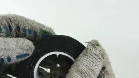 Hands unwind a roll of black electrical tape. Prepare for repair. Stock Footage 143015539