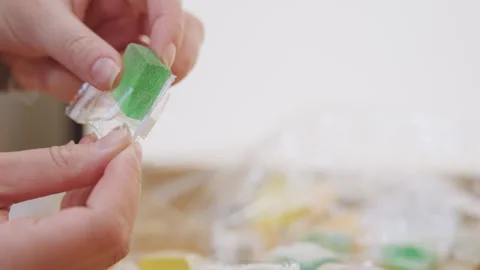 Hands unwrap candy. Unwrapping sweet treat carefully. Closeup of hands peeling Stock Footage 346222372