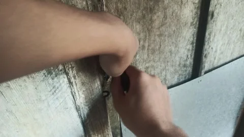 Hands use a key to unlock a weathered wooden door Stock Footage 313100565