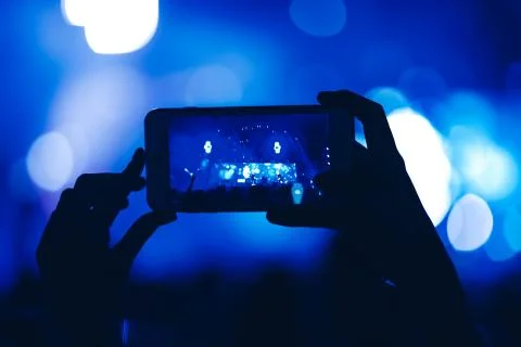 Hands use mobile phone for take a photo and video record at night music festi Stock Photos