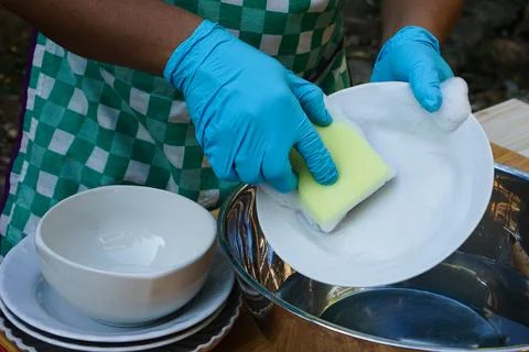Hands use sponge scrubber to clean dish. Foto stock