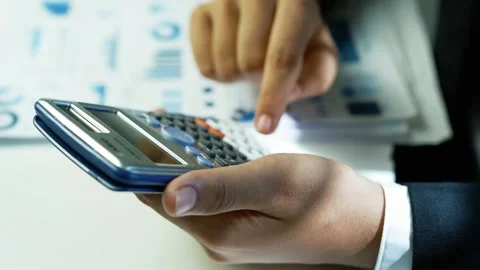 Hands Using Calculator on Desk with Documents Stock Footage 321223656