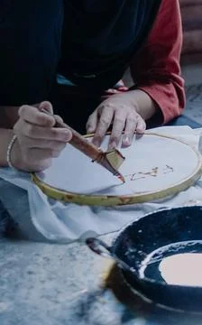 Hands Using Canting Tool to Draw Traditional Batik Pattern 库存照片