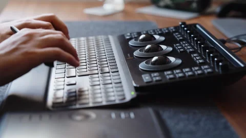 Hands Using Color Grading Control Panel and Keyboard in Modern Editing Workspace Stock Footage 345690338