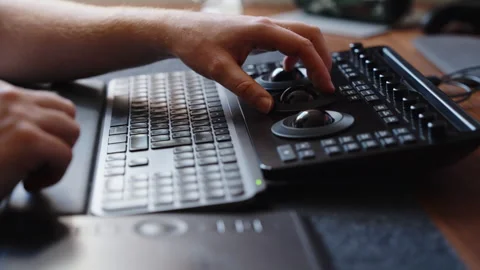 Hands Using Color Grading Control Panel and Keyboard in Modern Editing Studio Stock Footage 345690957