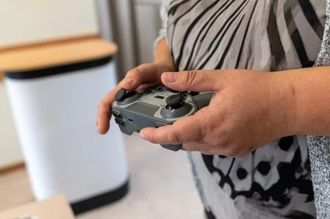 Hands using a game controller to operate a robot in a technology workshop 스톡 사진