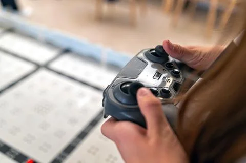 Hands using a game controller to operate a robot in a technology workshop Stock-Fotos