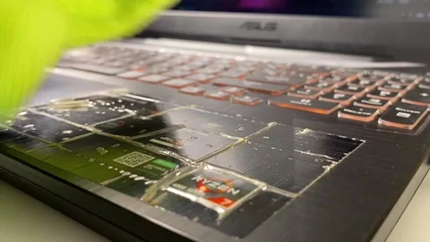 Hands using green wiper to clean keyboard button on gaming laptop close up Stock Footage 250594592