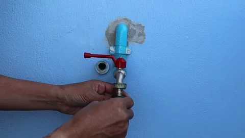 Hands is using hose connector with faucet on cement wall Stock Footage 146793786