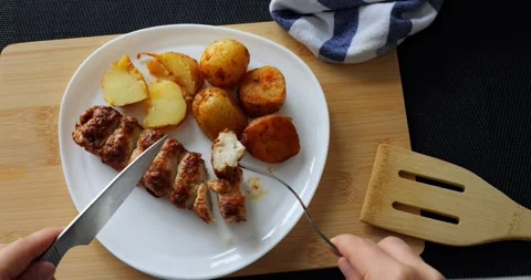 Hands using knife and fork cutting and picking a piece of grilled meatloaf Stock Footage 316755967