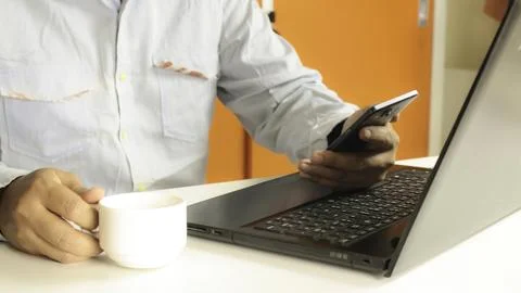 Hands using laptop and smartphone drinking coffee for online shopping Stock Photos