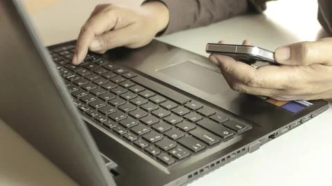 Hands using laptop and smartphone for online shopping with daytime soft lig.. 写真素材